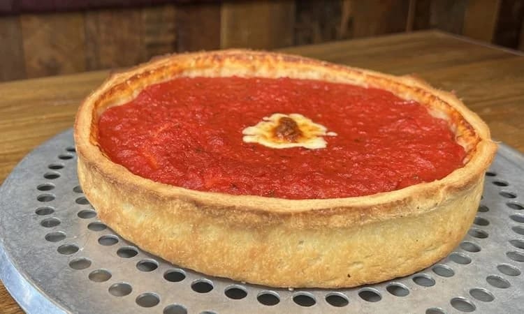 Freshly baked Chicago-style stuffed pizza with rich tomato sauce